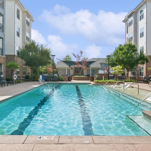 Relax and unwind poolside a swimming pool in a courtyard between buildings